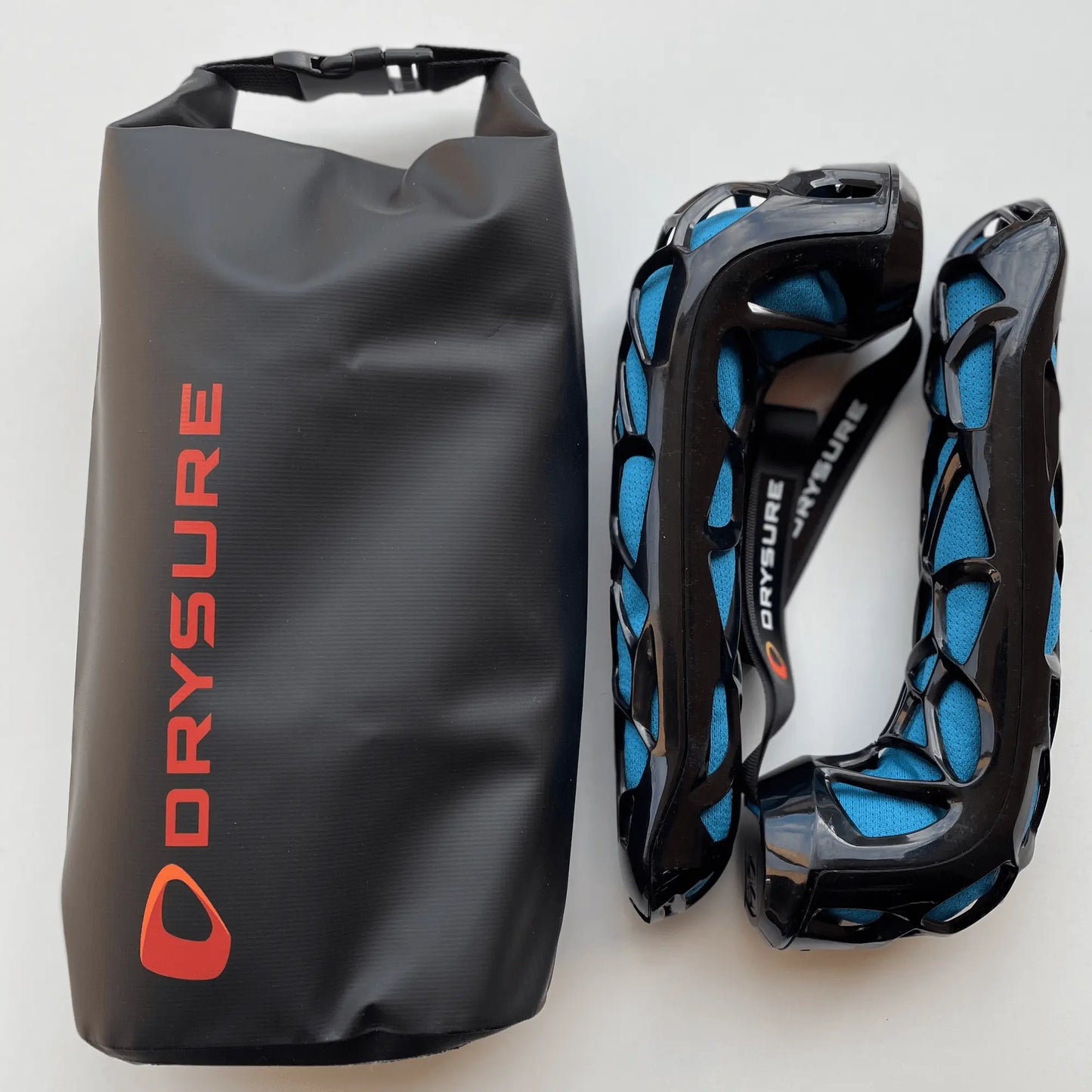 Drysure Active Shoe Dryer in blue with a black shell next to a drybag that says Drysure on it. The background is blank